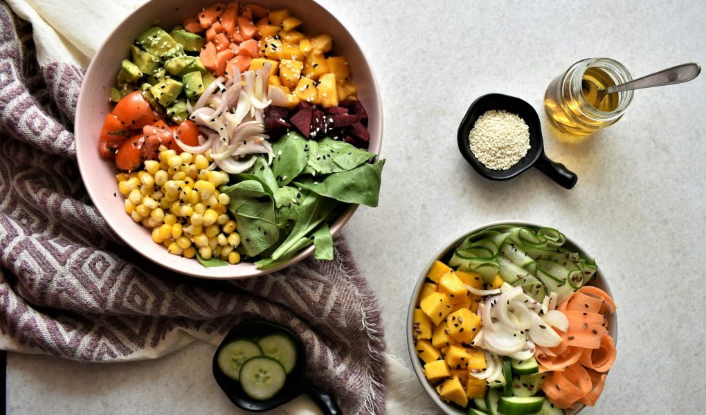 Bowls of chickpeas, vegetables and leafy greens on a table