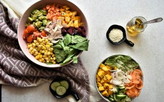 Bowls of chickpeas, vegetables and leafy greens on a table