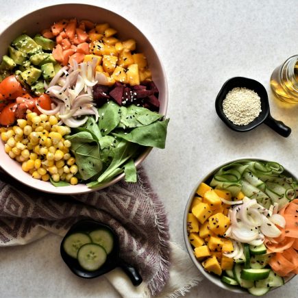 Bowls of chickpeas, vegetables and leafy greens on a table