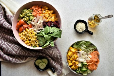 Bowls of chickpeas, vegetables and leafy greens on a table